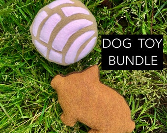 Può includere: Un set di due giocattoli per cani a forma di dolci messicani. Il primo giocattolo è una concha marrone e bianca, e il secondo giocattolo è un pan dulce marrone e beige. I giocattoli sono su un letto di erba verde. Il testo "DOG TOY BUNDLE" è in testo nero su sfondo bianco.
