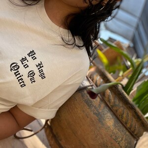 May include: A white t-shirt with black text that reads "Yo Hago Lo Que Quiero" in a gothic font.