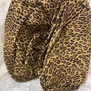 May include: A brown and black leopard print fabric with a gathered design.