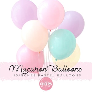 Peut inclure: Un bouquet de ballons de 25 cm de couleur pastel dans des tons de rose, lavande, jaune et bleu. Les ballons sont disposés en grappe et ont un aspect fantaisiste, semblable à celui des macarons. Le texte "Macaron Balloons" et "10 inches pastel balloons" est visible en bas de l'image. Le logo "Cheers Balloons" est également visible.