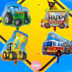 Op de afbeelding: Vier kleurrijke folie ballonnen in de vorm van voertuigen: een groene tractor, een geel bouwvoertuig, een rode brandweerwagen en een blauwe ijswagen met de tekst "Happy Birthday".