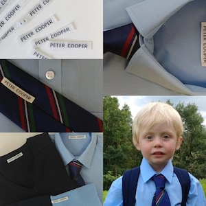 May include: A blue and white striped tie with red and green accents. The tie has a label that reads "Peter Cooper". There are several other labels with the same text in the image. The image also shows a blue shirt with a white collar and a boy wearing a blue shirt with a similar tie.