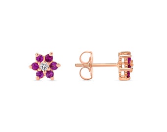 Puede incluir: Pendientes de botón de flor de oro rosa con un solo diamante blanco en el centro y piedras preciosas rosas alrededor.