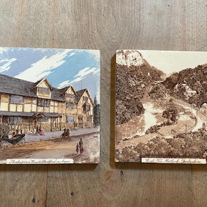 May include: Two vintage postcards depicting historical landmarks. The first postcard shows a Tudor-style house with a thatched roof and the text "Shakespeare's House Stratford on Avon". The second postcard shows a winding road through a mountainous landscape with the text "High Tor, Matlock, Derbyshire".