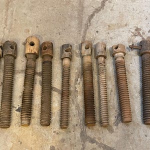 May include: Ten antique wooden screw clamps with a threaded metal shaft. The clamps are made of wood and have a natural finish. They are all different sizes and have varying degrees of wear and tear.