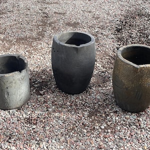 May include: A set of three ceramic mugs with a speckled, matte finish. The mugs are in shades of cream, light gray, and dark gray. Each mug has a simple, minimalist design, perfect for coffee or tea.