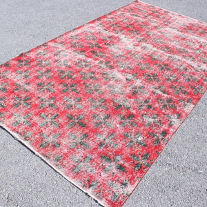 Könnte beinhalten: Ein roter und grüner Vintage-Teppich mit einem Blumenmuster. Der Teppich hat einen abgenutzten Look und ist aus Wolle.