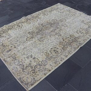 Könnte beinhalten: Ein großer, rechteckiger Teppich im Vintage-Stil mit einem komplizierten Blumenmuster in Beige-, Creme- und Brauntönen. Der Teppich hat einen Used-Look mit verblichenen Bereichen und einer weichen, abgenutzten Textur, was darauf hindeutet, dass es sich um ein antikes Stück oder eine Reproduktion handelt.
