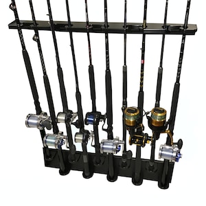 May include: A black fishing rod rack holding multiple fishing rods with reels. The rods are black with silver and gold accents. The rack is made of black wood and is designed to hold the rods vertically.