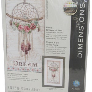 Pode incluir: Um kit de ponto cruz contado Dimensions Floral Dreamcatcher. O kit inclui fio pré-selecionado, tecido Aida branco de 14 contagens, agulha e instruções. O design apresenta um apanhador de sonhos com detalhes florais e a palavra "DREAM". Mede 20,3 cm x 38,1 cm.