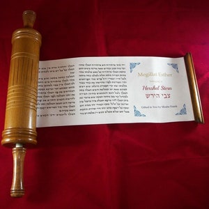 May include: A wooden scroll with Hebrew text on a white background. The scroll is titled "Megillat Esther" and "Hebrew Story" in English. The scroll is on a red fabric background.