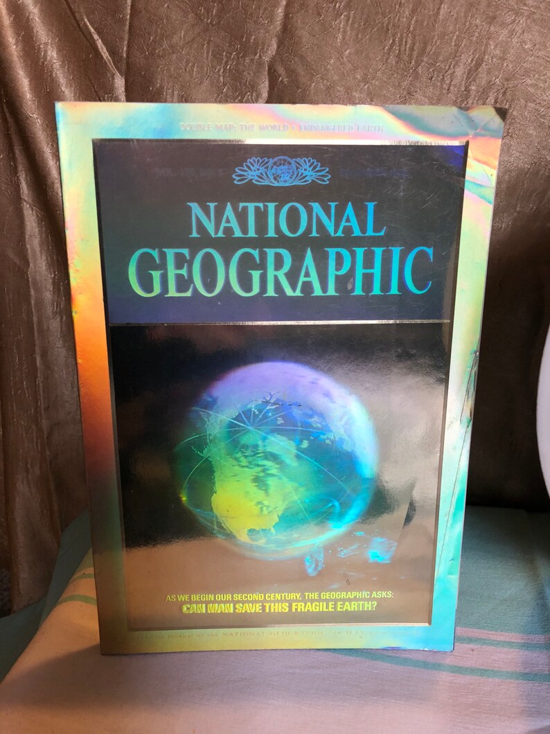 Chein 9\u201d metal globe and 1988 Nat Geo Holographic earth magazine