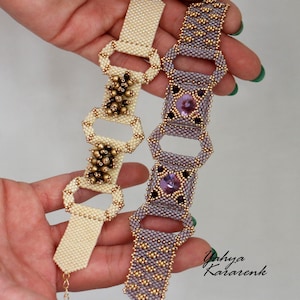 Op de afbeelding: Twee kralenarmbanden met gouden accenten. De ene armband is ivoor met gouden kralen en de andere is paars met gouden kralen en een paarse edelsteen.