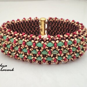 Könnte beinhalten: Ein Armband aus Perlen in Braun, Gold, Grün und Rot. Das Armband ist aus kleinen Perlen gefertigt und hat einen Verschluss.