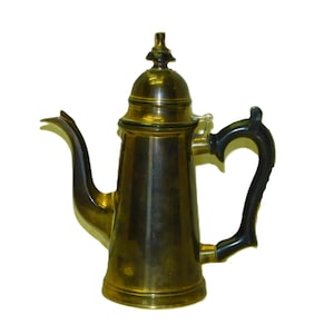 May include: A vintage brass coffee pot with a black handle and a decorative finial on the lid. The pot has a long, curved spout and a classic, elegant design. The brass has a warm, golden hue.