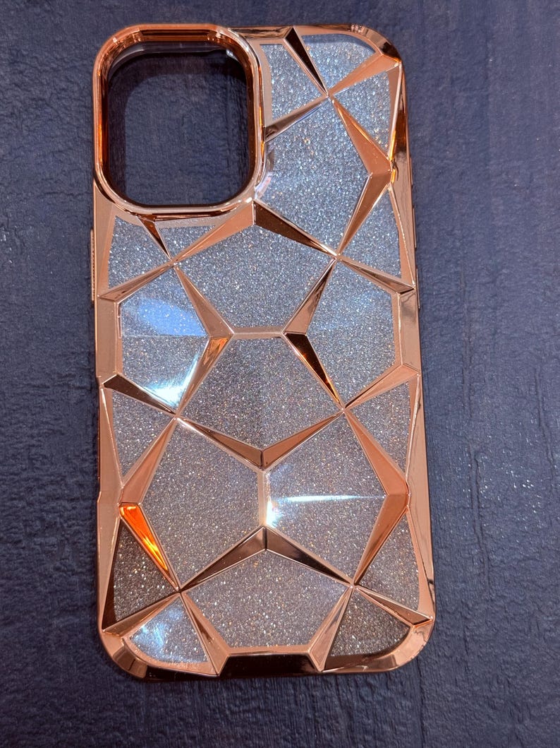 May include: A rose gold phone case with a geometric design and a glittery finish.