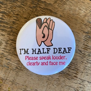 Puede incluir: Botón blanco con una mano rosa sosteniendo una oreja y el texto "Soy medio sordo. Por favor, habla más alto, claro y de frente."