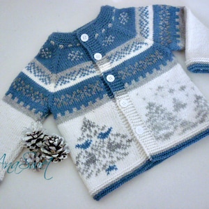 May include: A blue and white knitted baby cardigan with a snowflake and tree pattern. The cardigan has a button closure and is made with a soft yarn.