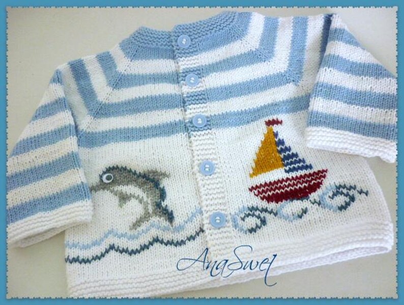 May include: A blue and white striped knitted cardigan with a sailboat and dolphin design. The cardigan has a button closure and is made of soft yarn.