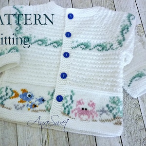 May include: White knitted cardigan with a sea life design. The cardigan has blue buttons and features a fish, crab, and seaweed. The text "PATTERN knitting" is visible in the top left corner.