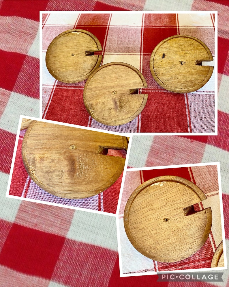 K&ouml;nnte beinhalten: Ein Satz von vier Weinflaschenverschl&uuml;ssen aus Holz. Jeder Verschluss ist kreisf&ouml;rmig mit einem Schlitz f&uuml;r den Korken und einem kleinen Holzstift. Die Verschl&uuml;sse sind aus hellfarbigem Holz gefertigt und auf einer rot-wei&szlig; karierten Tischdecke angeordnet.