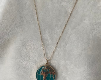 Gold World globe locket pendant on a gold necklace