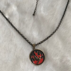 Antique bronze mockingjay  mockingbird bird  “fire within” pendant medallion on a bronze colored necklace