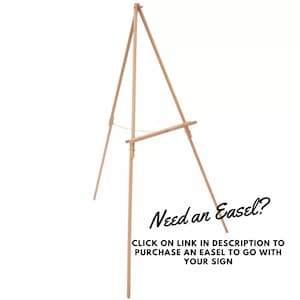 May include: A wooden easel with a light brown finish. The easel is made of three legs that form a triangular base. The easel is designed to hold a sign or artwork.