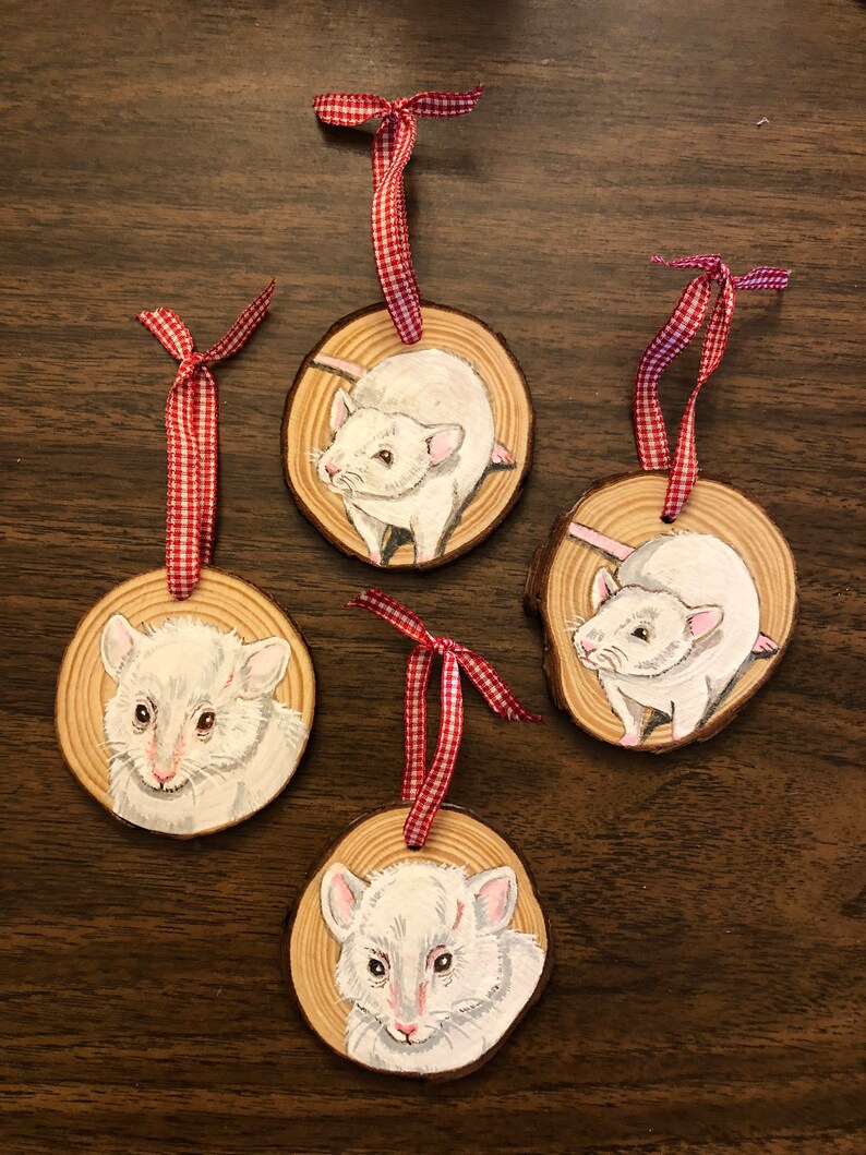 May include: Four white rat ornaments painted on wood slices with red and white gingham ribbon.