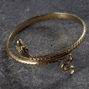 Op de afbeelding: Een gouden slangenarmband met een gedetailleerd slangendesign. De armband is open en klaar om te dragen.