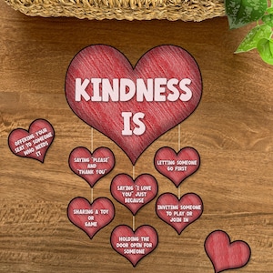 May include: Red heart-shaped graphic with the words "Kindness is" in white text.  Surrounding the main heart are smaller red hearts with phrases describing acts of kindness, such as "Offering your seat to someone who needs it", "Saying 'Please' and 'Thank you', "Sharing a toy or game", "Holding the door open for someone", "Saying 'I love you' just because", "Letting someone go first", and "Inviting someone to play or join in".
