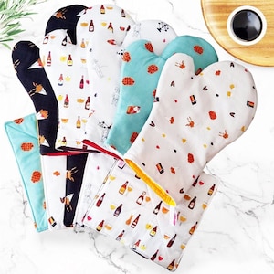 Può includere: Set di sei guanti da forno con diversi motivi. I guanti sono bianchi con vari disegni colorati, tra cui bottiglie di birra, bicchieri e pretzel. I guanti sono realizzati in un tessuto morbido e trapuntato.