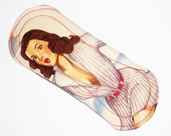 May include: A white fabric pad with a red and white striped design featuring a vintage illustration of a woman with dark hair wearing a striped shirt and a red belt.