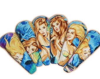 May include: Six fabric mermaid-themed covers in blue, green and yellow colours. Each cover features a mermaid with long flowing hair and a seashell design.