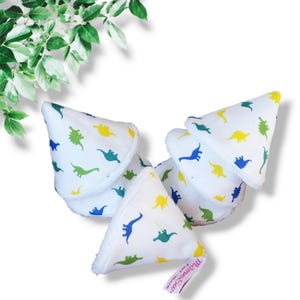 May include: Set of five white reusable nursing pads with a dinosaur print in blue, green, and yellow. The pads are cone-shaped and have a label that reads "The Green Cup".