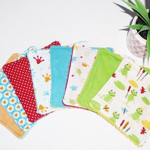 May include: A set of eight colorful fabric squares with different patterns, including hearts, crowns, frogs, and polka dots. The squares are made of soft, absorbent fabric and are perfect for cleaning up spills or wiping away messes.