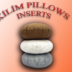 Pode incluir: Tr&ecirc;s insertos de almofada redondos de Kilim empilhados uns sobre os outros. O inserto superior &eacute; castanho, o inserto do meio &eacute; branco e o inserto inferior &eacute; cinzento.
