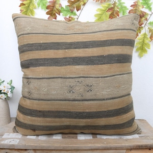May include: A striped throw pillow with a beige and brown color scheme. The pillow has a woven texture and a subtle pattern.
