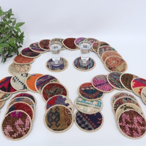 May include: A set of 25 colorful round coasters made from recycled rug material. Each coaster features a unique pattern and design. The coasters are perfect for protecting surfaces from scratches and spills.