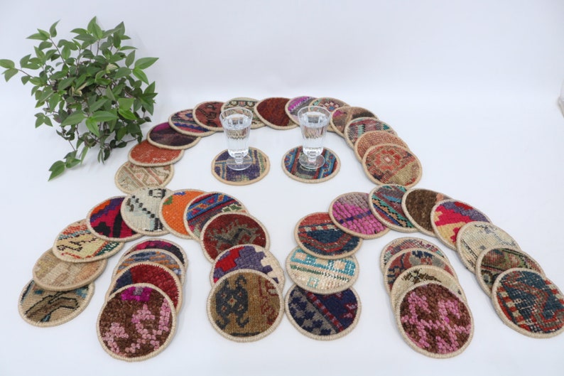May include: A set of 25 colorful round coasters made from recycled rug material. Each coaster features a unique pattern and design. The coasters are perfect for protecting surfaces from scratches and spills.