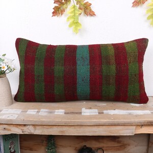 May include: A rectangular pillow with a red, green, and blue striped pattern. The pillow is made of woven fabric and has a soft, textured surface.