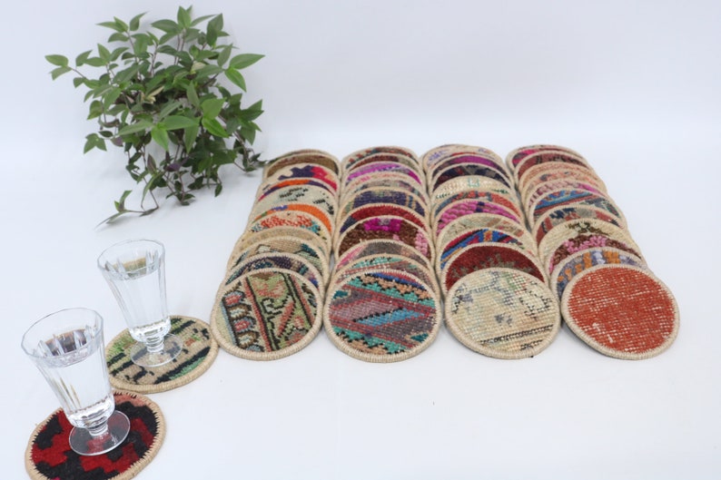 May include: A set of 25 colorful round coasters made from repurposed rug scraps. Each coaster features a unique pattern and color combination. The coasters are perfect for adding a touch of bohemian style to your home.