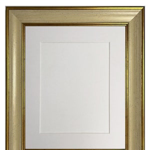 May include: A gold picture frame with a white mount and a white background. The frame has a textured surface and a gold trim.