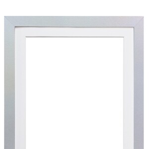May include: A silver picture frame with a white mount. The frame is empty and ready for a photo or artwork.