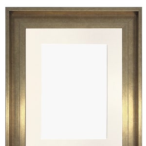 May include: A gold-toned picture frame with a white mat. The frame has a simple, classic design.