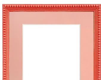 May include: A coral-colored picture frame with a beaded border and a light pink mat.