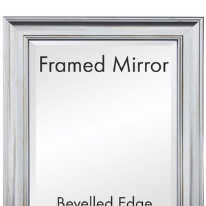 Peut inclure: Un miroir encadré avec un bord biseauté. Le cadre est de couleur gris clair avec une finition vieillie.