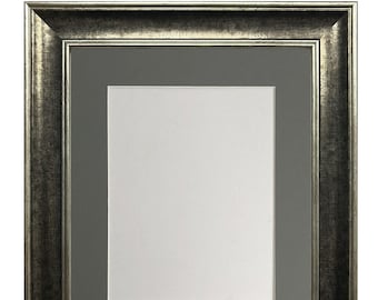 Könnte beinhalten: Ein silberner Bilderrahmen mit einem grauen Passepartout. Der Rahmen hat ein dekoratives, verziertes Design.