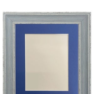 Peut inclure: Un cadre photo en bois gris avec un passe-partout bleu. Le cadre a un aspect vieilli et est parfait pour afficher des photos ou des &oelig;uvres d'art.