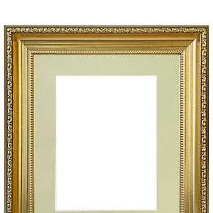 Peut inclure: Un cadre photo doré avec un design orné décoratif. Le cadre a un passe-partout de couleur crème.